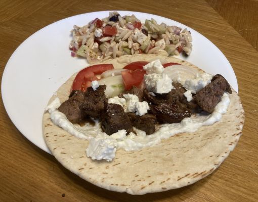 Grilled lamb served in pita with salad on a plate