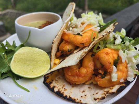 Plate of shrimp tacos with lime and sauce