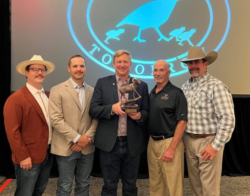 Men at a wildlife fundraising event posing with an award.