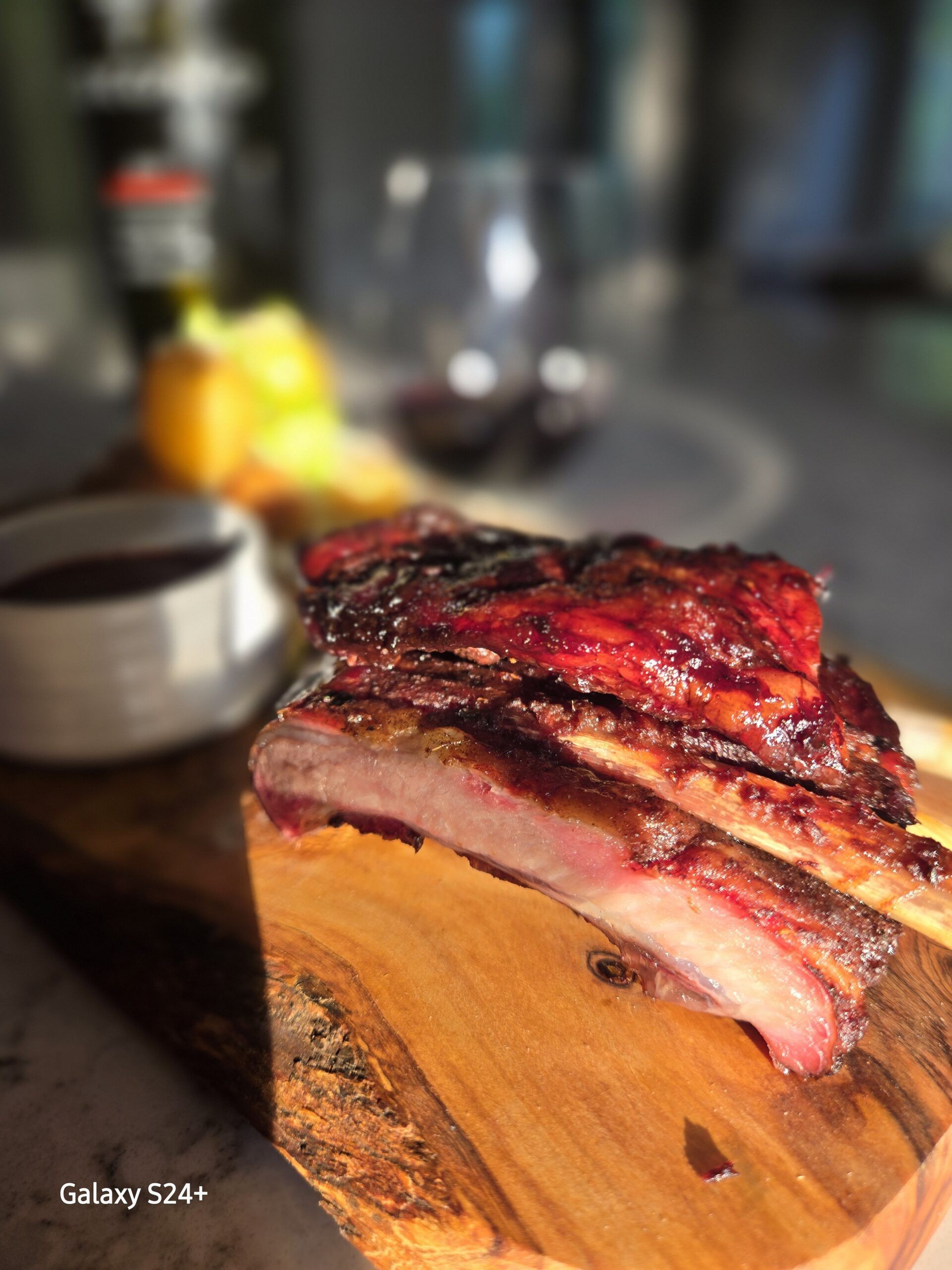 Delicious smoked ribs presented on a wooden board with sides.