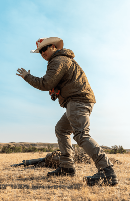 Hunter action shot in dry grassland with clear sky.