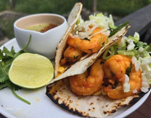 Plate of shrimp tacos with lime and sauce
