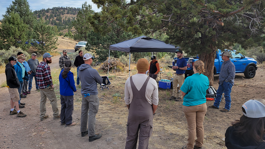 Group of individuals attending a conservation training event outdoors.