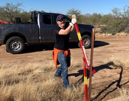 Volunteer participating in fence building for conservation efforts.