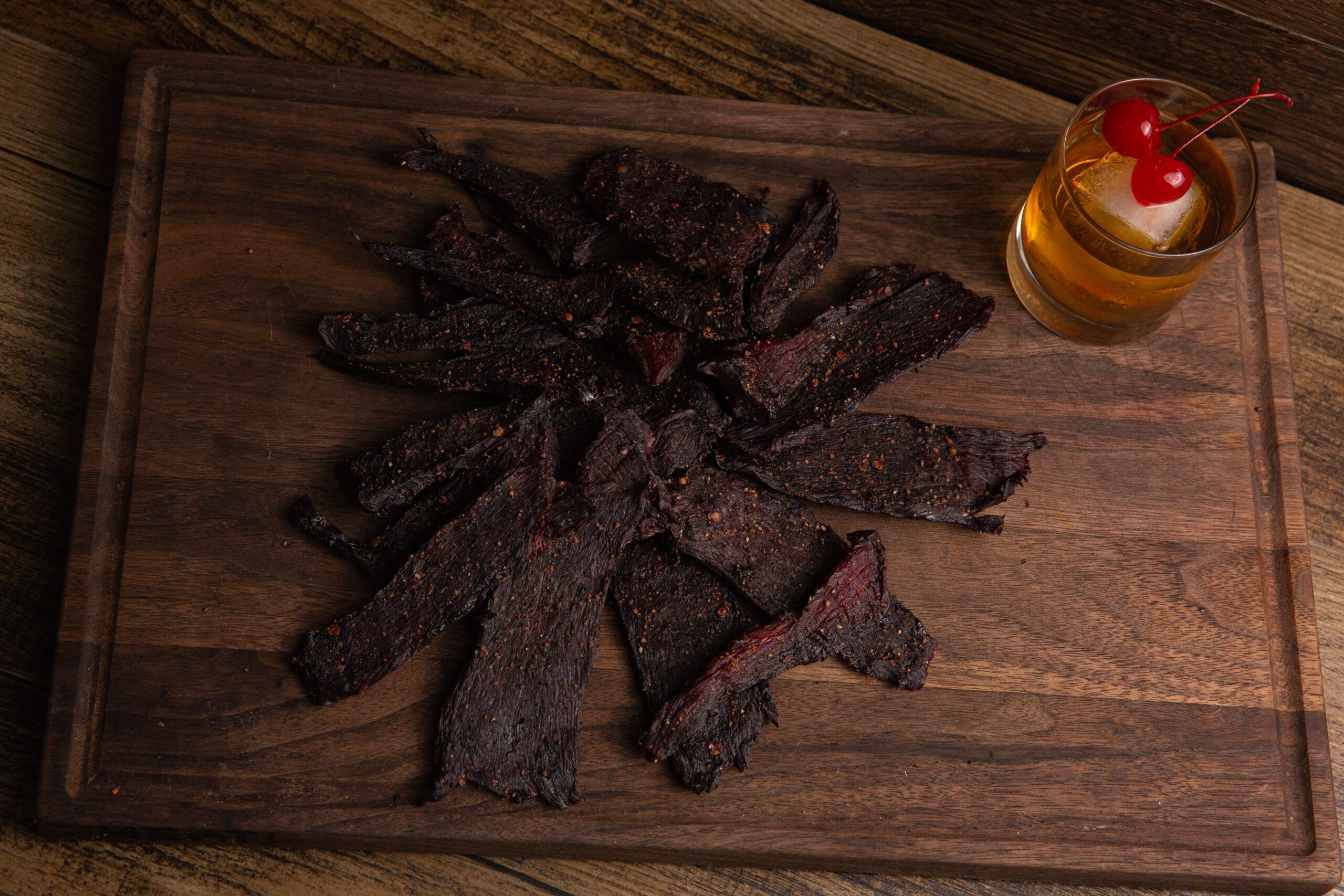 Plate of venison jerky with a drink