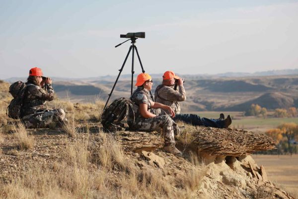 Hunters observing the landscape with binoculars