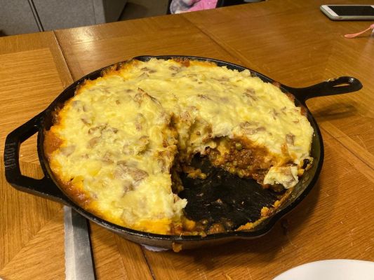 Casserole in skillet with serving taken out