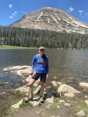 Hiker standing by a mountain lake