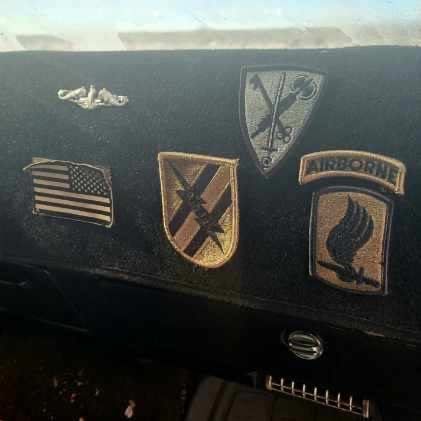 Dashboard display of military patches and insignia.
