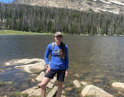 Hiker standing by a mountain lake