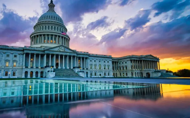 U.S. Capitol Building at sunset with reflections in the foreground