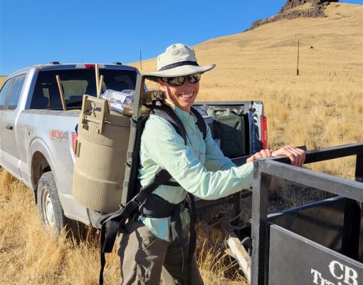 Volunteer in habitat conservation wearing gear outdoors.