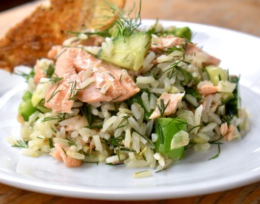 Salmon rice salad served on a white plate with a slice of toasted bread.