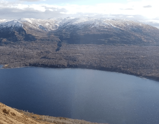 A serene view of a lake surrounded by snow-capped mountains.