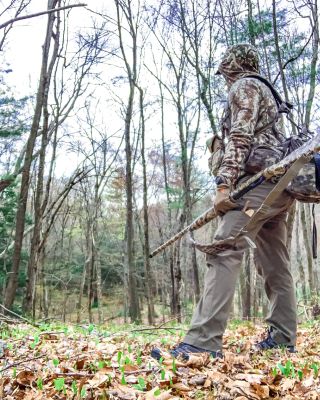 Hunter in camouflage observing the woods