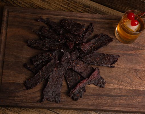 Plate of venison jerky with a drink