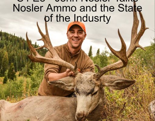 A hunter poses with a mule deer in a forested area.