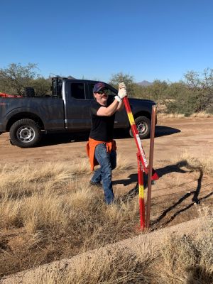Volunteer participating in fence building for conservation efforts.