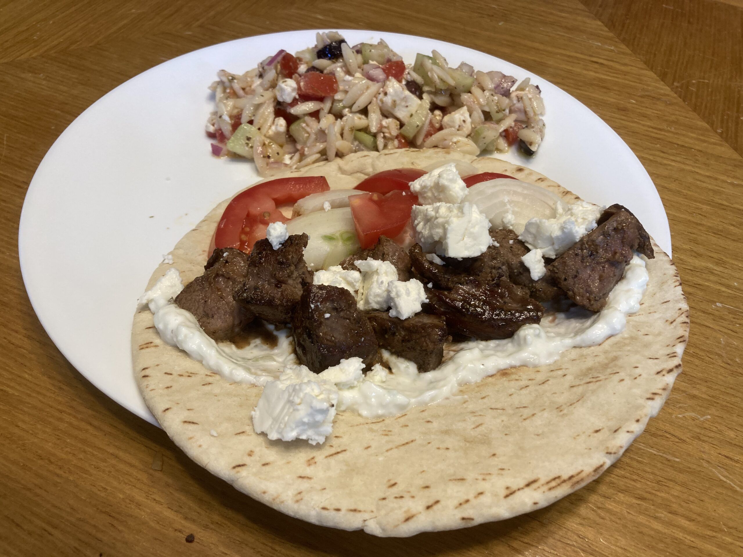 Grilled lamb served in pita with salad on a plate
