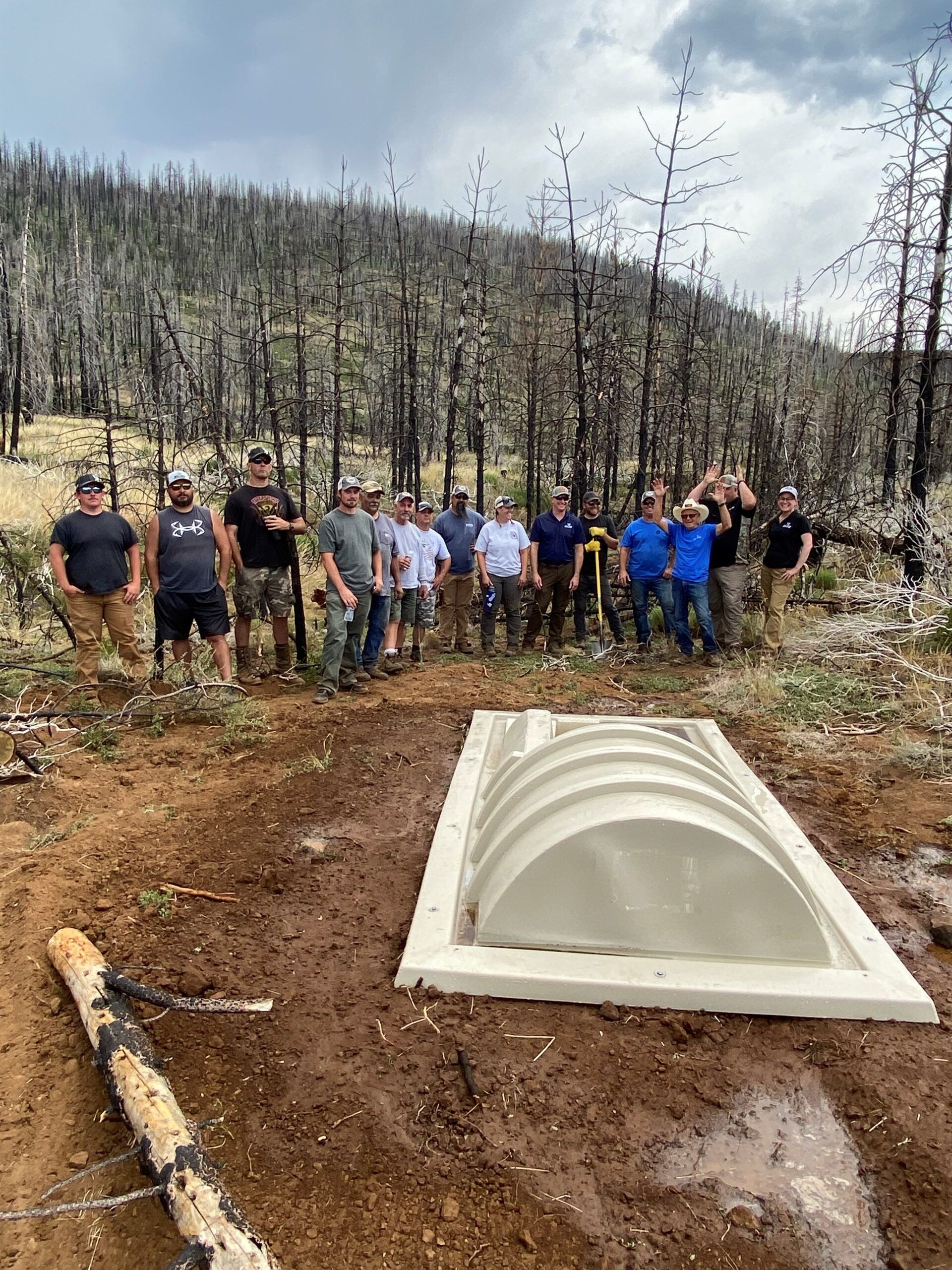 Group of volunteers at a habitat restoration site with a newly constructed structure.