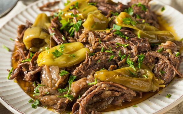 Pulled venison served with peppers and herbs on a plate.