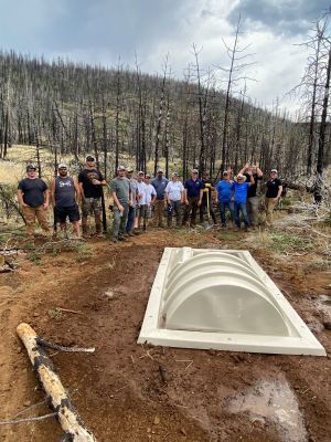 Group of volunteers at a habitat restoration site with a newly constructed structure.