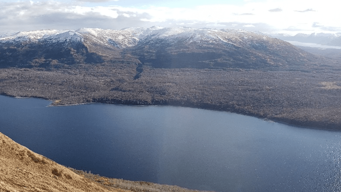 A serene view of a lake surrounded by snow-capped mountains.