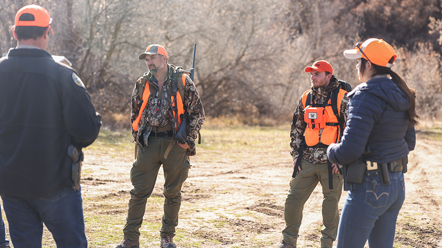 Group of hunters discussing safety in the field.