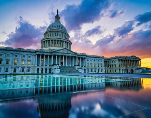 U.S. Capitol building at sunset with reflections