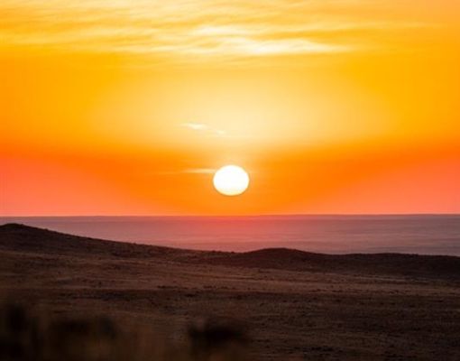Stunning sunset view over open plains with vibrant colors.