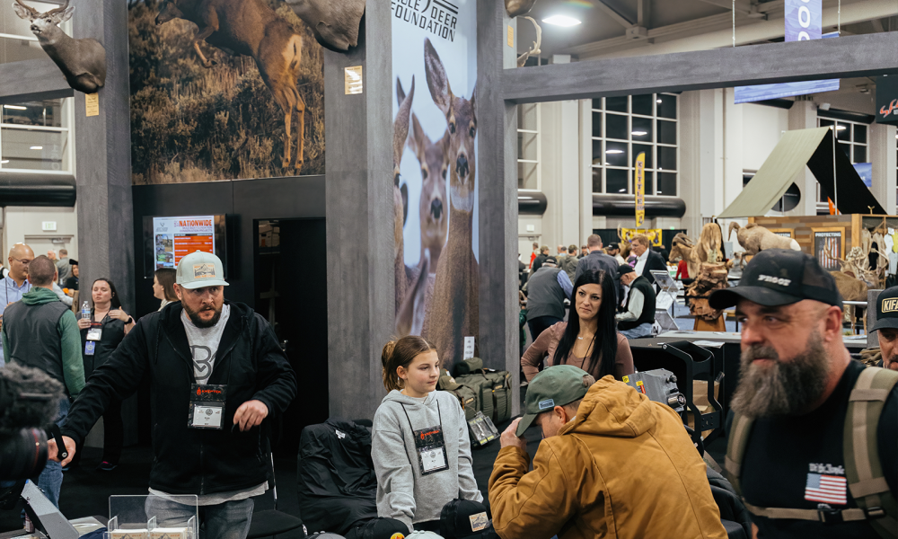 Mule Deer Foundation event booth with attendees browsing merchandise.