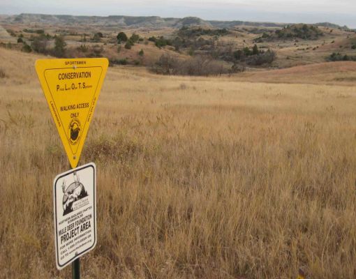 Sign for Mule Deer Foundation conservation area with grasslands