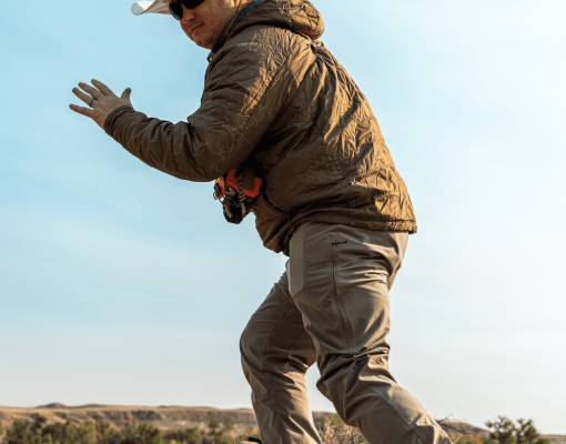 Hunter action shot in dry grassland with clear sky.