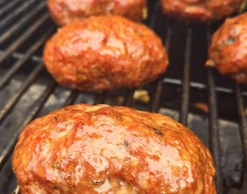 Grilled meatloaf cooking on barbecue grill.