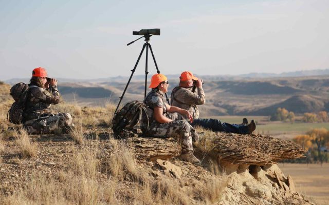 Hunters observing the landscape with binoculars