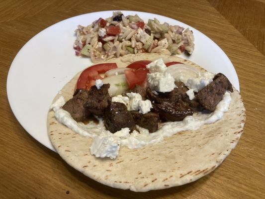 Grilled lamb served in pita with salad on a plate