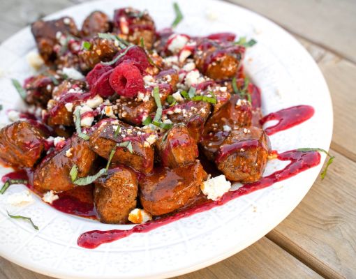 Delicious meatballs topped with raspberry sauce and fresh basil.