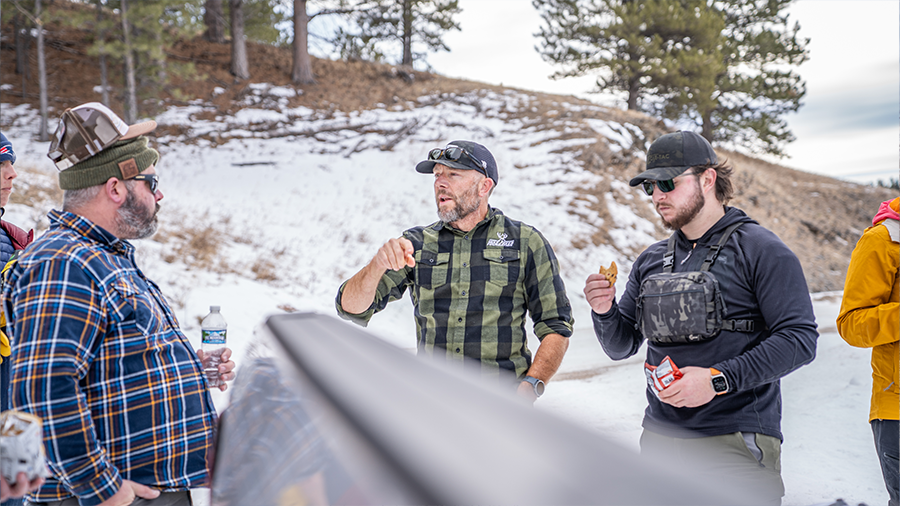 Group talking at a community engagement outreach event in snowy terrain.