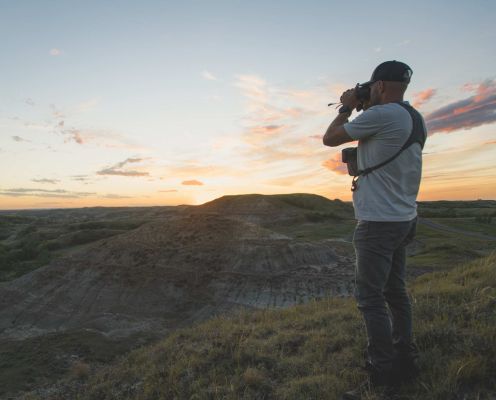 Photographer taking a picture of a sunset landscape