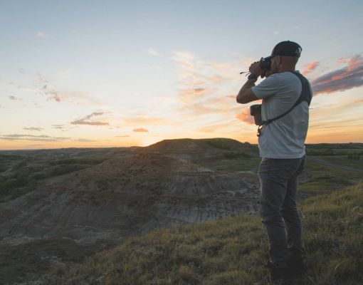 Photographer taking a picture of a sunset landscape