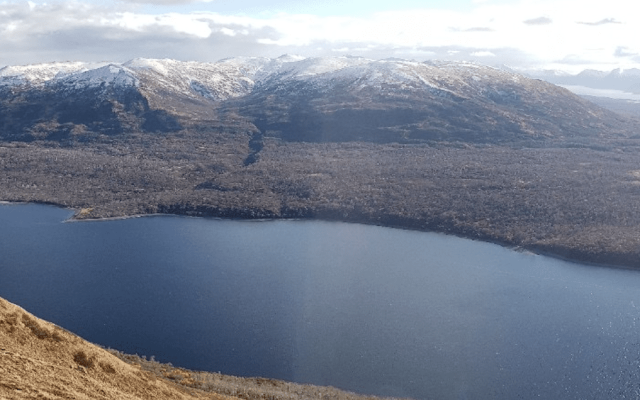 A serene view of a lake surrounded by snow-capped mountains.