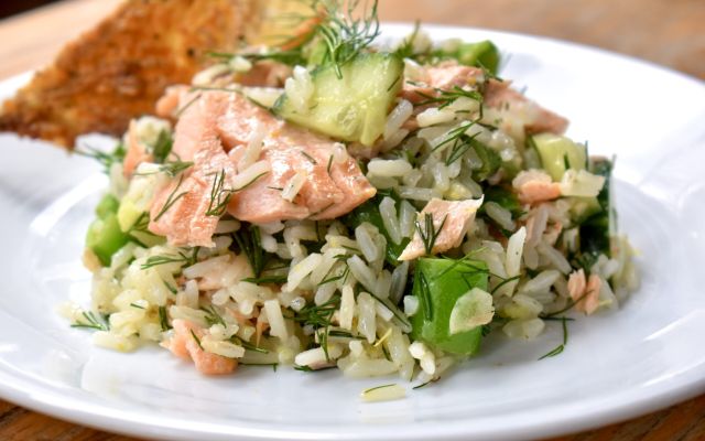 Salmon rice salad served on a white plate with a slice of toasted bread.