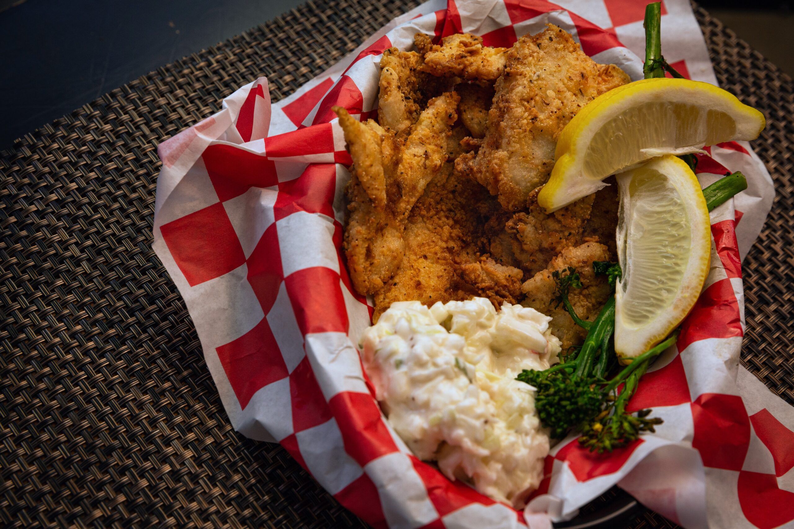 Plate of fried fish with coleslaw and lemon slices