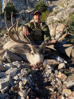 Mule deer hunter in mountainous rocky setting