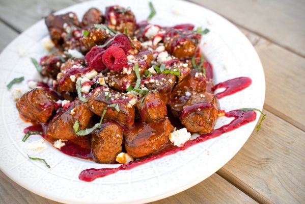 Delicious meatballs topped with raspberry sauce and fresh basil.