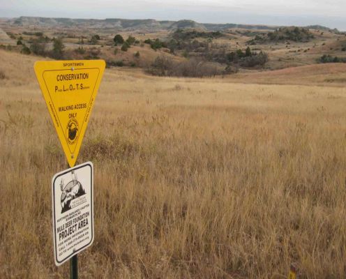 Sign for Mule Deer Foundation conservation area with grasslands