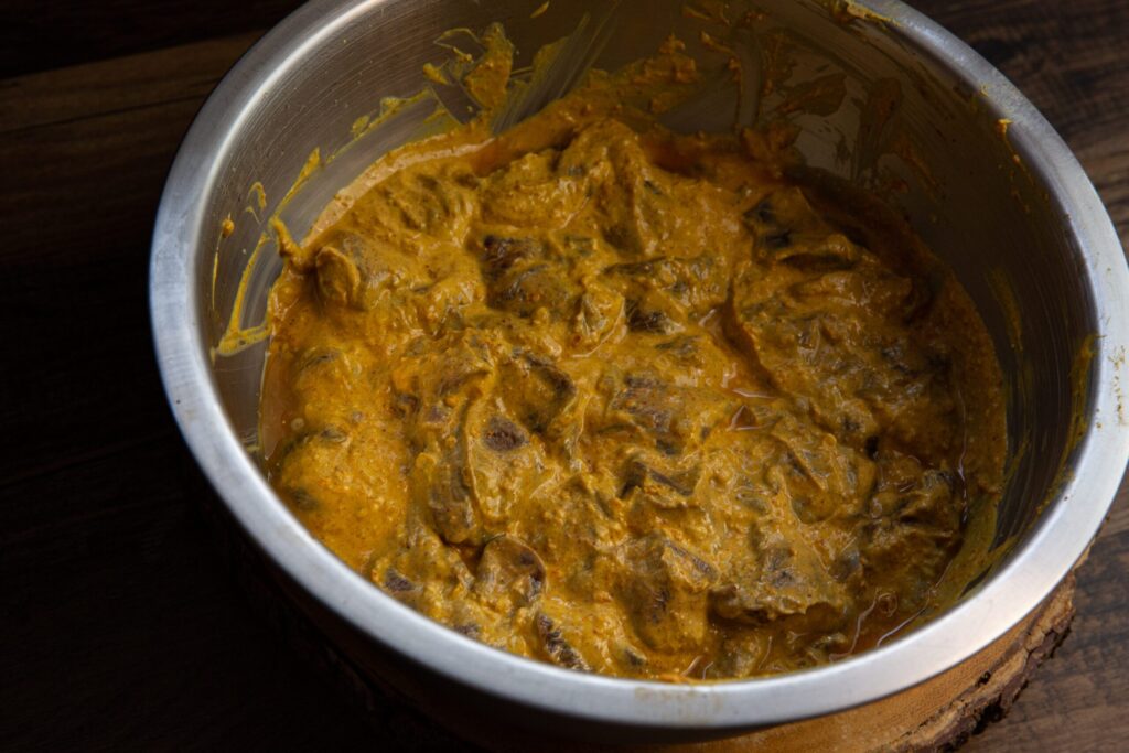 Marinated venison meat in a bowl for cooking.