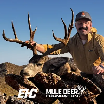 Hunter posing with harvested mule deer