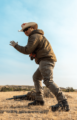 Hunter action shot in dry grassland with clear sky.