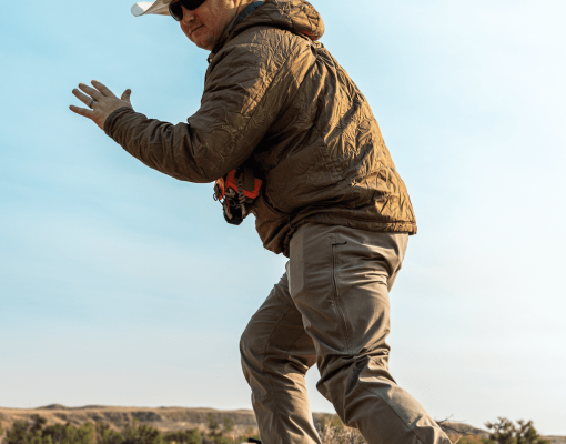 Hunter action shot in dry grassland with clear sky.